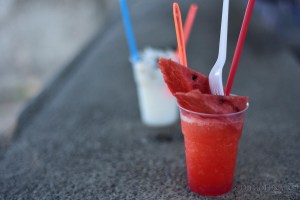 Un bicchiere di grattachecca con anguria fa bella mostra di sé, insieme a un altro con la famosa lemoncocco