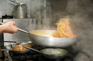 Dopo aver saltato gli spaghetti in padella, il cuoco prepara le porzioni