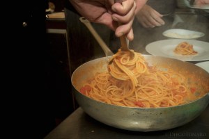 La preparazione degli spaghetti all'amatriciana in un ristorante romano