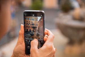 Dettaglio di uno smartphone nell'atto di scattare una foto alla fontana